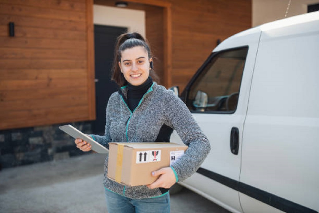 Female delivery worker deliver a parcel to customer at home.Business logistics import export shipping or freight transportation.